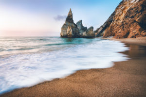 Portugal Ursa Beach. Sea stacks, white ocean wave lit by sunset light. Portugal Ursa Beach. Sea stacks, white ocean wave lit by sunset light.